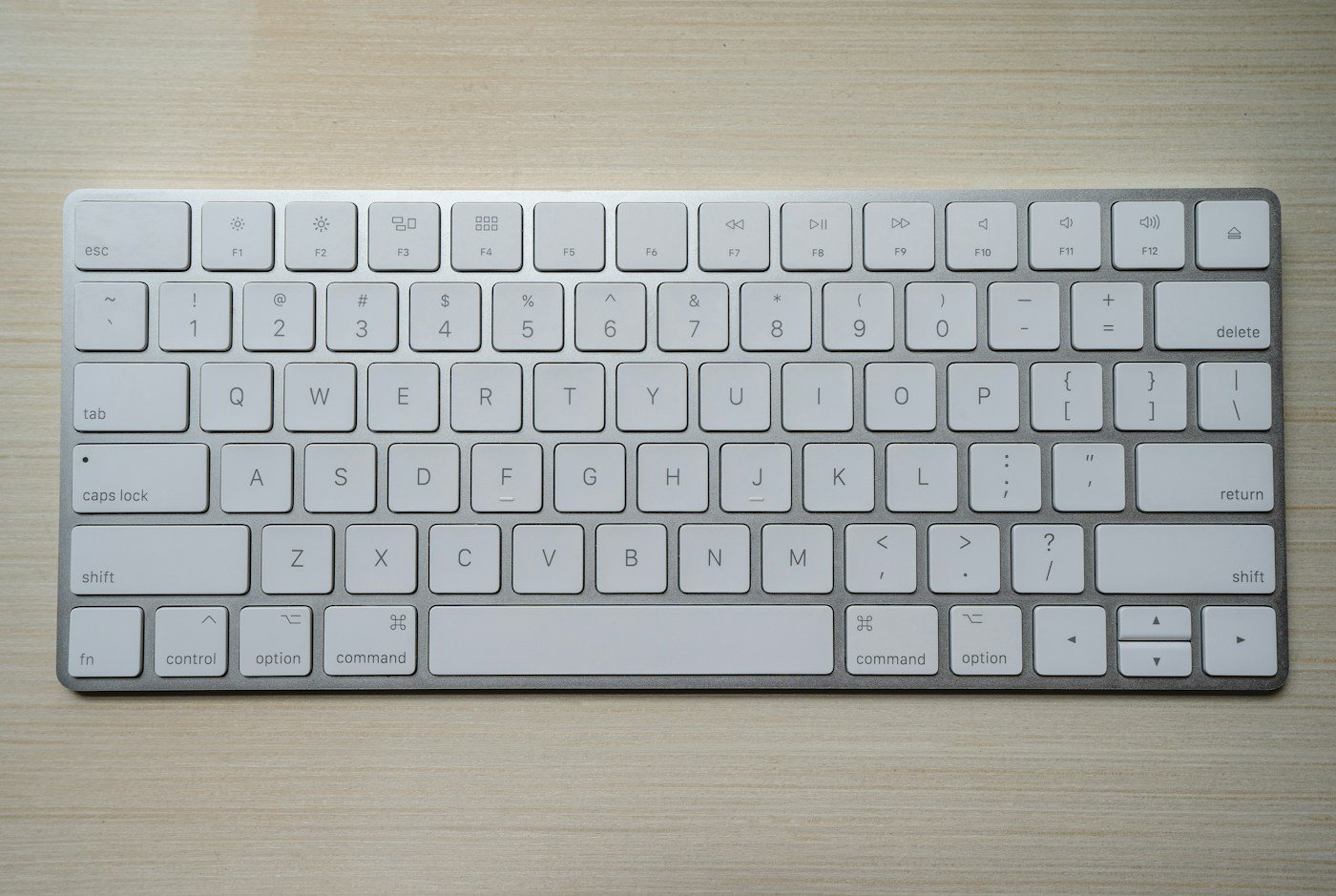 A compact white computer keyboard viewed from above
