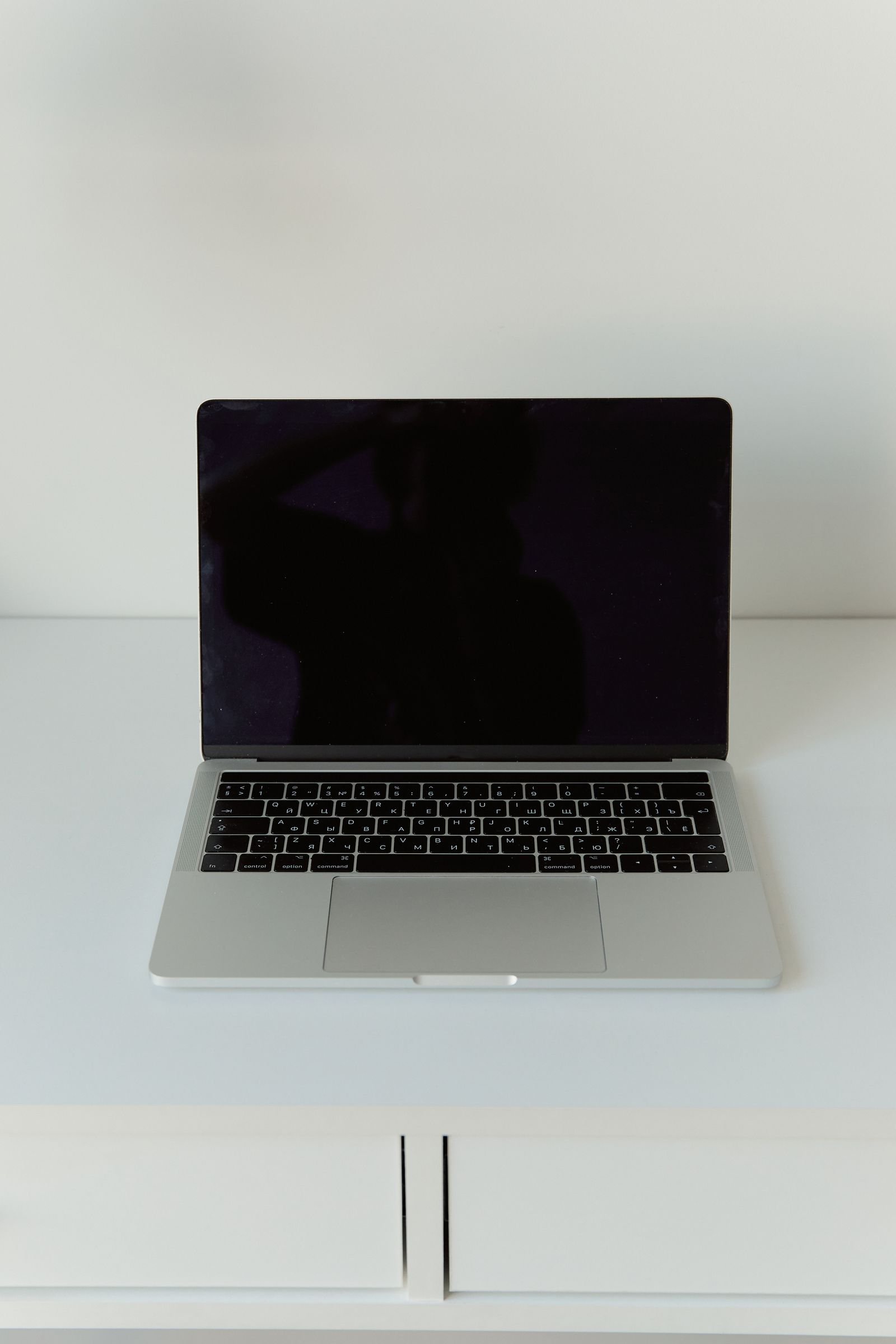 An open laptop on a minimal light-coloured desk